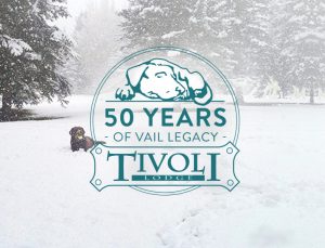 50 Years of Vail Legacy at Tivoli Lodge logo with chocolate labrador playing in the snow.