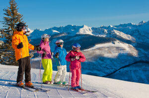 family ready to ski down a mountain