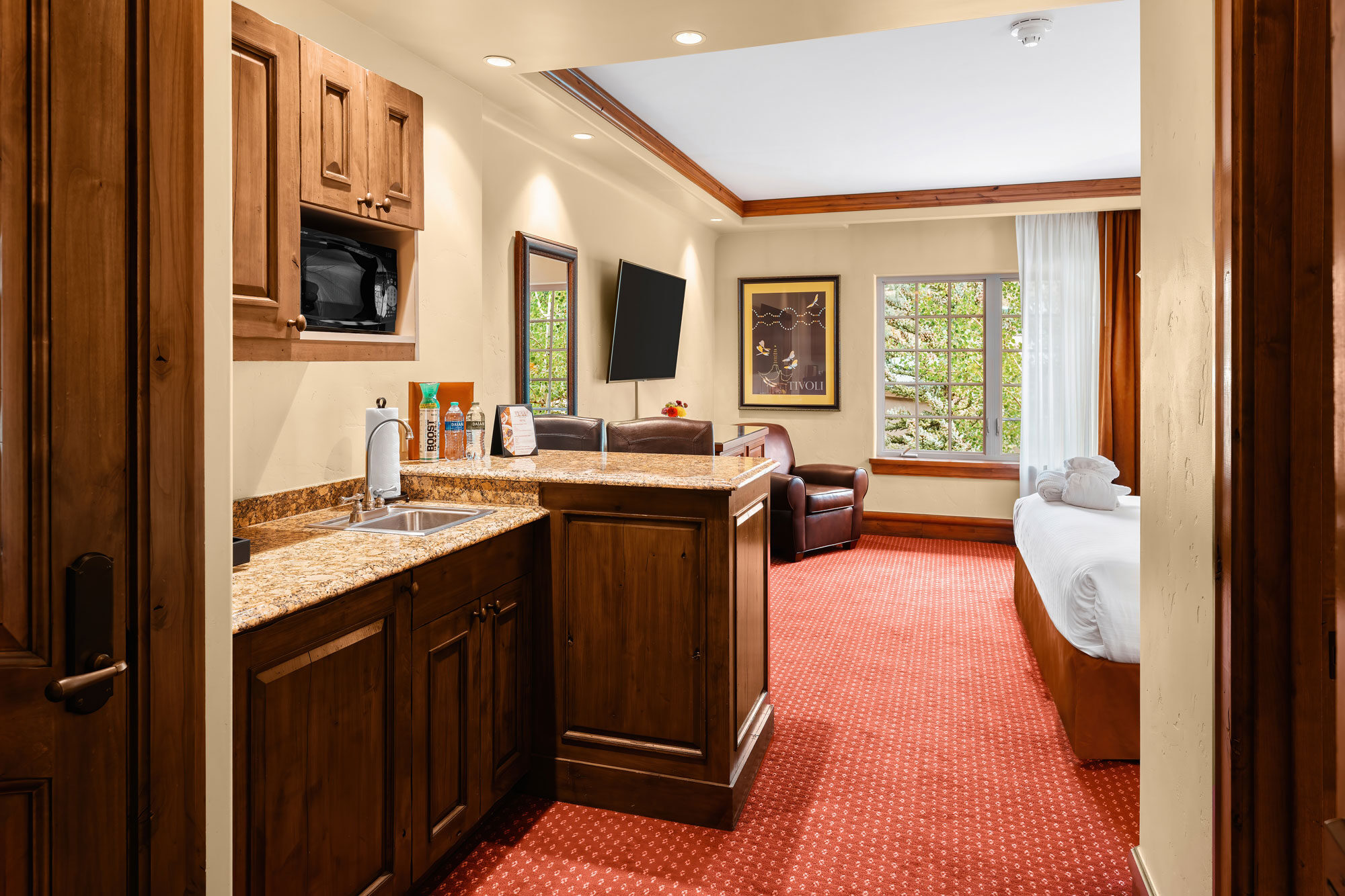 kitchenette, king bed, leather chair in village view room