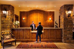 guest checks in with front desk employee at the Tivoli Lodge Vail Colorado