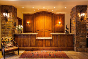 photo of front desk with wood panels and stone accents at the Tivoli Lodge Vail Colorado