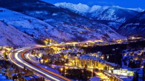 Vail village lights up at night with mountains in background Tivoli Lodge Vail Colorado