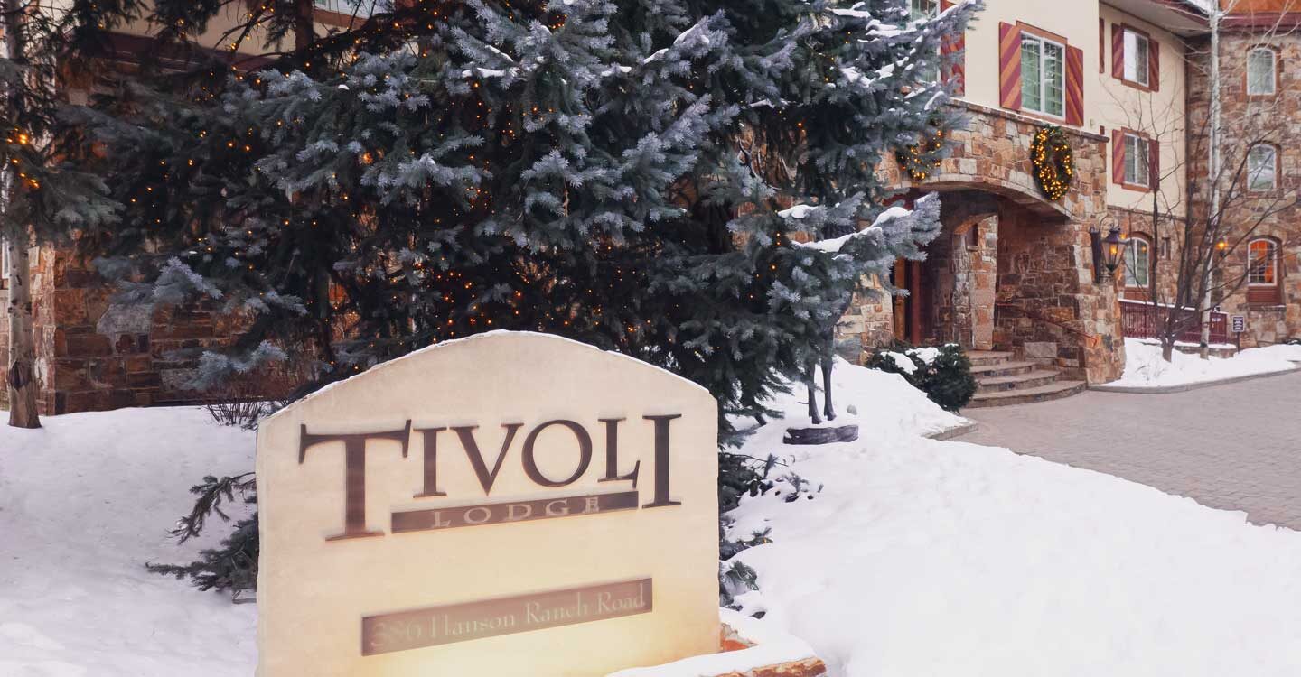 outside the Tivoli Lodge Vail Colorado with stone sign and steps going inside