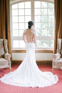 bride in her dress look out the window of the Seibert Suite Tivoli Lodge Vail Colorado