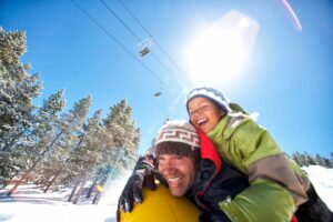 father and child go snow tubing down the hill Tivoli Lodge Vail Colorado