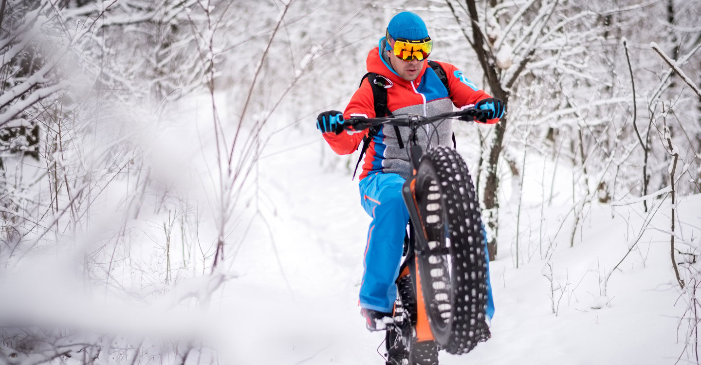 man tries biking in the snow using thick bicycle tires Tivoli Lodge Vail Colorado