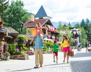 family of four enjoy walking in Vail Village with daughter on dad's shoulders Tivoli Lodge Vail Colorado