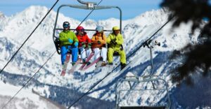 four friends ride ski lift on a sunny winter day in Vail Tivoli Lodge Vail Colorado