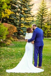 bride and groom sneak a kiss during their fall wedding Tivoli Lodge Vail Colorado