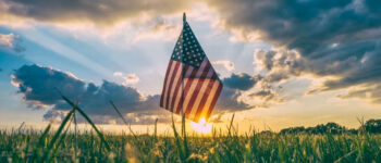 small American flag in ground with sun setting Tivoli Lodge Vail Colorado